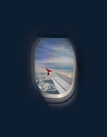 Wing of an airplane flying above the city. The view from an airplane window. Cloudy and color sky...
