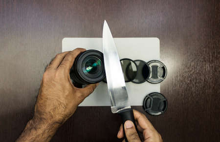 Cutting photo lenses on wooden table. Creative photographer concept photoの写真素材