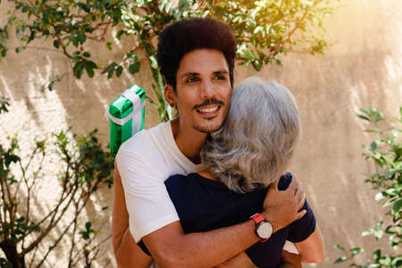 Caucasian mother and her black son in the house garden.  Happy interracial family.の写真素材