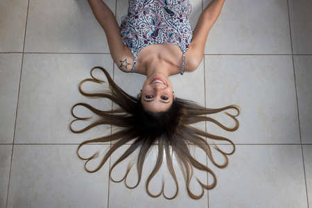 Girl lying on the floor with heart shaped hair.の写真素材
