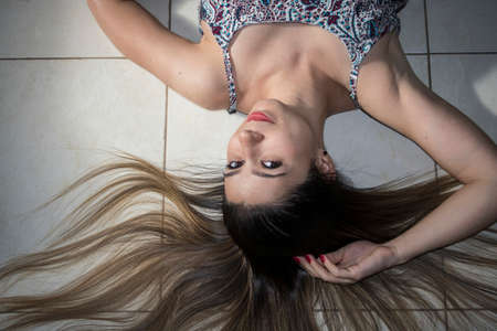 Girl lying on the floor with heart shaped hair.の写真素材