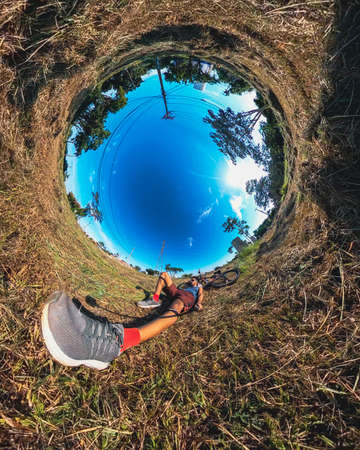 World bicycle day - Black man having fun riding a bicycle in the city park. 360 selfie modern photographyの写真素材