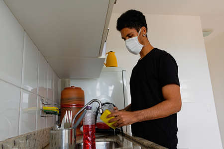 Man adult black washing dishe in kitchen.