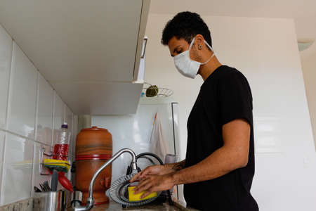 Man adult black washing dishe in kitchen.の写真素材