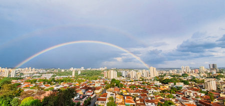 Rainy day in the city with heavy clouds and Rainbow. Ribeirao Preto City Skyline, famous city in...