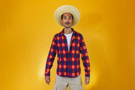 Black man wearing traditional clothes for Festa Junina isolated on yellow backgroundの写真素材