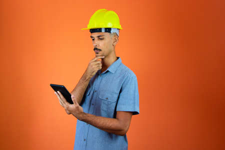 Engineer Holding Mobile isolated on Orange.