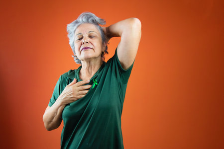 World mental health day - Mature Woman With Gray Hair, green ribbon and shirt isolated.の写真素材