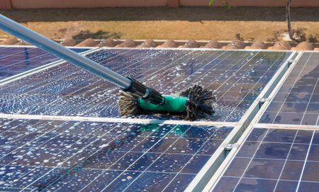 Solar worker cleaning photovoltaic panels with brush and water. Photovoltaic cleaning, before and...