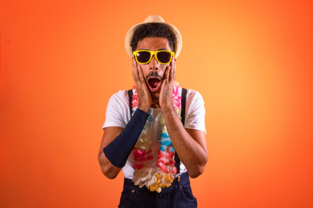 Carnival Outfit Party. Portrait of a Worry Black Man With Carnival Props Isolated on Orange...