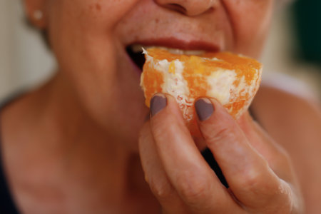 A Mature Brazilian Woman Eating an Orange Fruit at Her Home