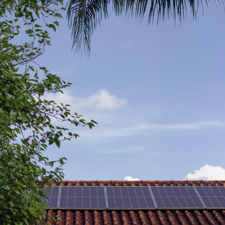 Solar panels on the red roof in a sunny and cloudy day.