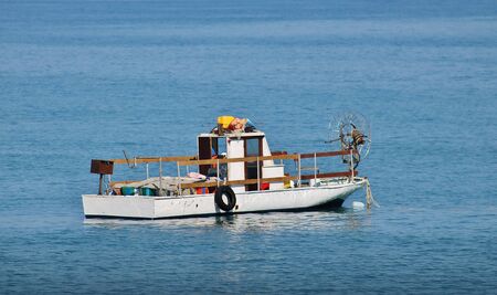 Little fishing boat in blue seaの写真素材