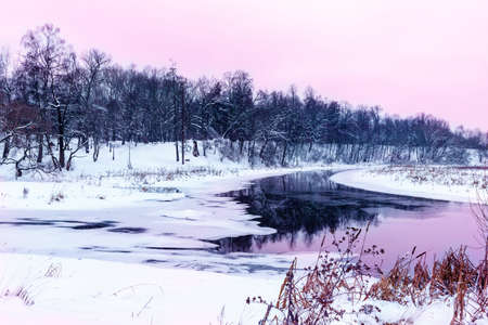 River in winter. Beach in the snow. Reflection in water.