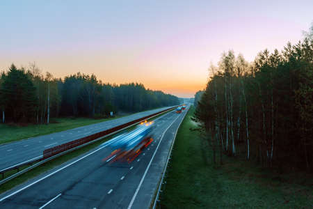 morning landscape with high-speed traffic on the highway with slow shutter speed to blur movement