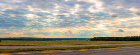 Panorama. A beautiful cloudy sky at sunset over a wide fieldの写真素材
