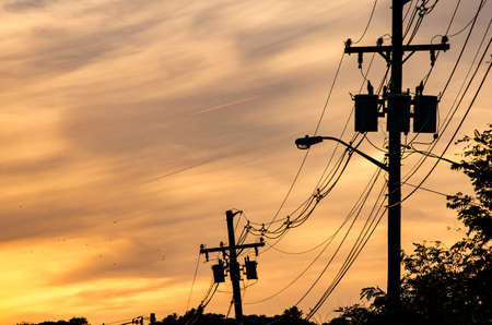 Utility poles against a sunet sky.の写真素材