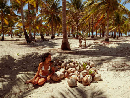 Woman holding coconut shells in the palm tree jungle in Onok island in Balabac Palawan in Philippinesの写真素材