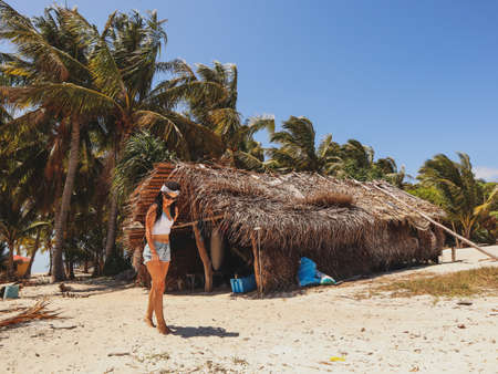 Woman in the wooden shelter surounded with palm trees in Onok Island in Balabac Philippines