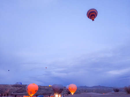 Colorful hot air balloons flying over the valley with fairy chimneys in winter season.のeditorial素材