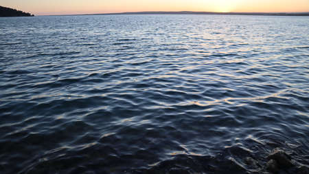Orange gold sunset on sea surface. Sun reflection on water. Landscape under colorful sky at sunset....