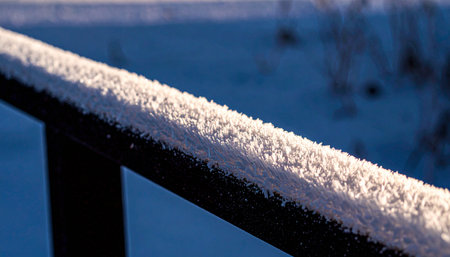 Realistic macro close-up of snow park metal rail with frost crystals and icy textures under soft morning light, minimal winter sports concept, no humans, no text.の素材