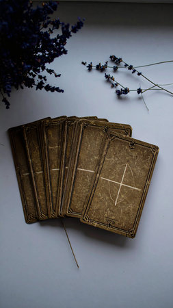 Simple, modern layout of three tarot cards placed on a pristine white surface with a single sprig of dried lavender, clean shadows, minimalist design for contemporary use, no people, ample copy space for text or design integration, photorealistic.の素材