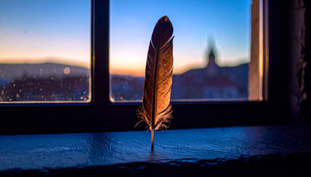 natural brown feather placed diagonally on dark black slate stone surface with natural soft light, minimal calm setupの素材