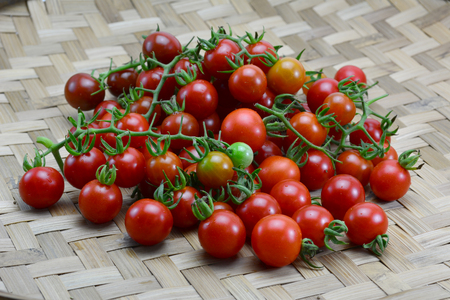 fresh tomatoes with green leaves isolated on white backgroundの写真素材