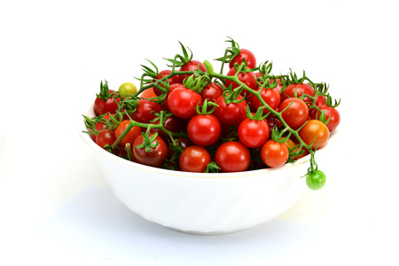 fresh tomatoes with green leaves isolated on white backgroundの写真素材