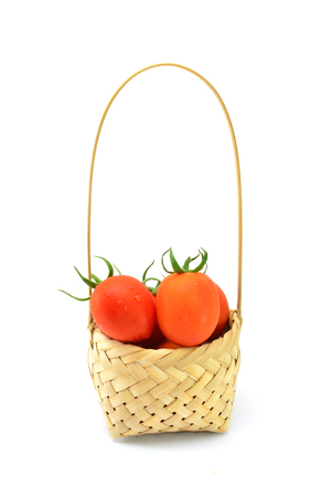 Tomato in basket wood on white backgroundの写真素材