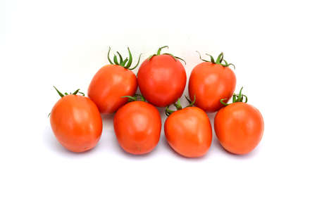 fresh tomatoes with green leaves isolated on white backgroundの写真素材