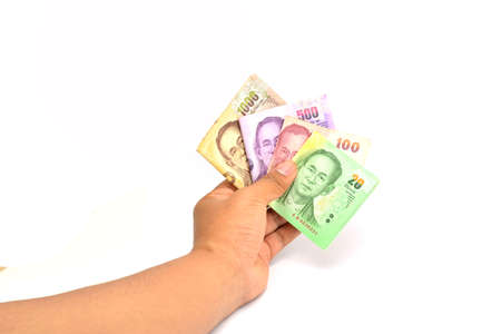 Hand holding Thailand money on white soft focus