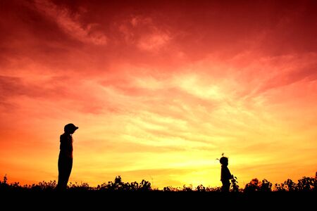 Silhouette children playing at sunsetの写真素材
