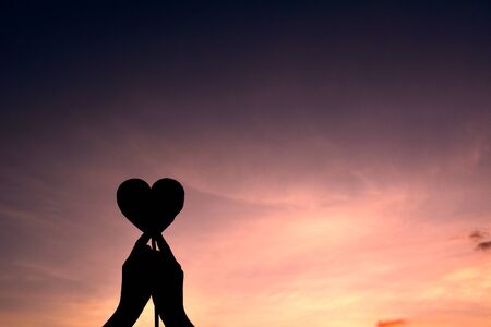 Silhouette hand holding heart shape