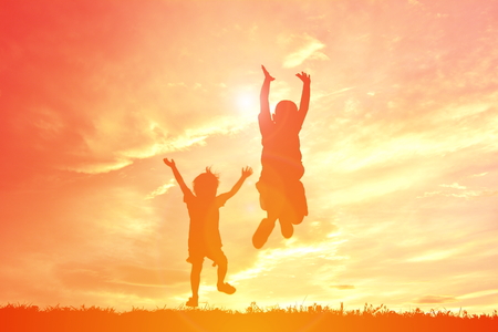 Silhouette children playing on sunsetの写真素材