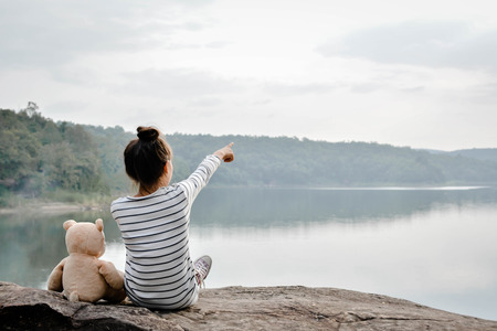 Happy asian children with teddy bear in nature ,relax time on holiday , vintage tone and soft focusの写真素材