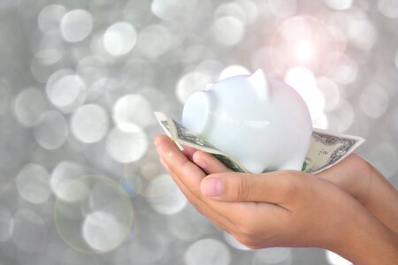 Hand holding dollar banknote and piggy bank . Soft focusの写真素材