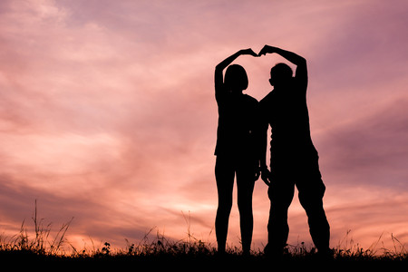 Silhouette women and man of lovers at the sky sunset, concept valentine day color of vintage toneの写真素材