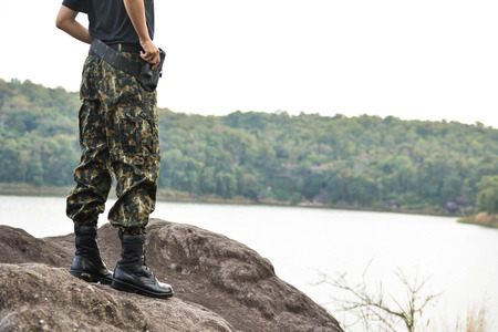 Soldier stand on the rock in nature backgroundの写真素材