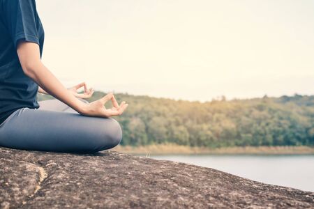 Women yoga in nature near river, color of vintage toneの写真素材