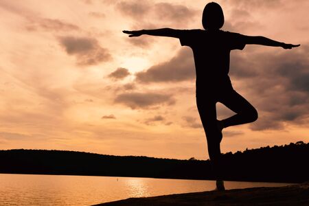 Silhouette women yoga in nature at the sky sunset, color of vintage toneの写真素材
