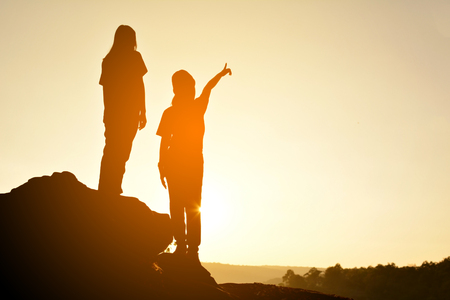 Silhouette of happy women on the rock near the river, color of vintage toneの写真素材