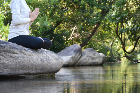 Women yoga in nature near river, color of vintage tone selective and soft focusの写真素材
