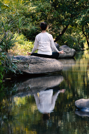 Women yoga in nature near river, color of vintage tone selective and soft focusの写真素材