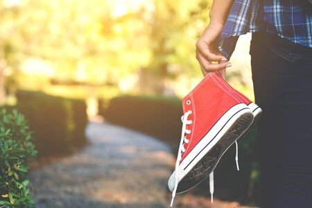 Hipster women holding red sneaker in the park and relax time on holiday. vintage toneの写真素材