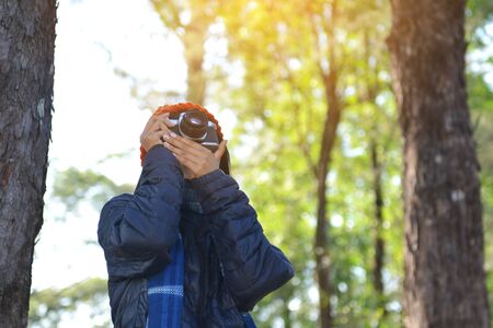 Asian women holding a camera shooting in nature and relax time on holiday.concept travel color of vintage toneの写真素材
