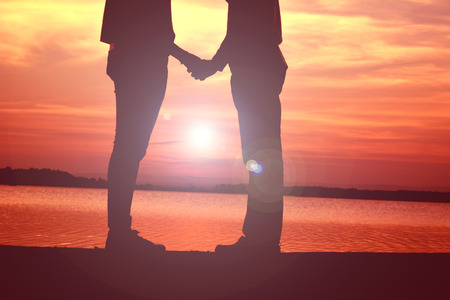 Silhouette women and man of lovers at the sky sunset, concept valentine day color of vintage toneの写真素材