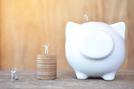 miniature worker team and white piggy bank on wood concept to save money , soft focusの写真素材