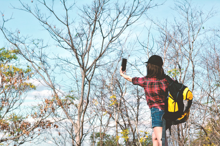 Happy Asian hipster women backpack in nature background, Relax time on holiday concept travel , color of vintage tone and soft focusの写真素材